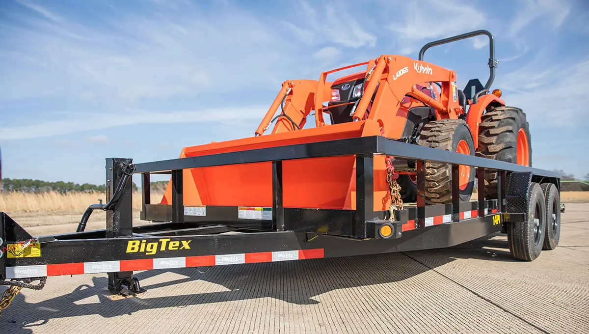 a big tex trailer with an orange tractor on it