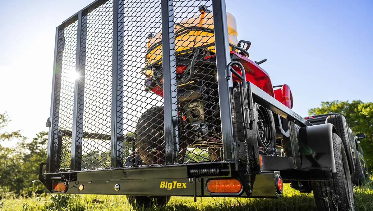 a 30sa tube top utility big tex trailer with a tractor on it