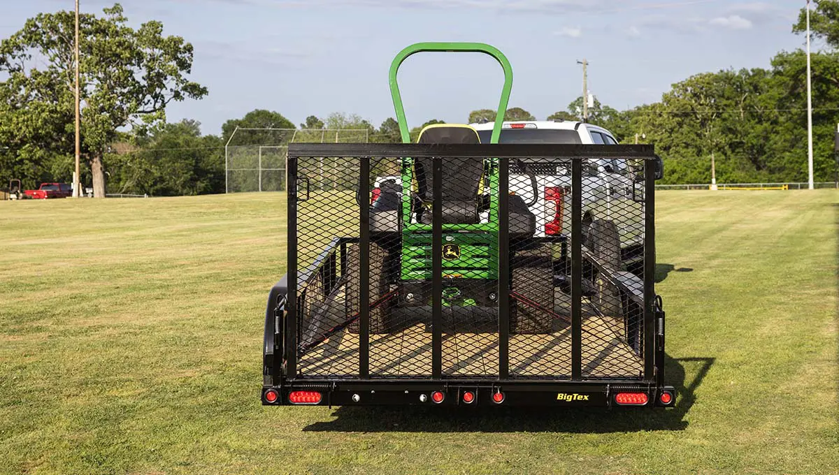 a 60pi tube top utility trailer with a john deere tractor on it