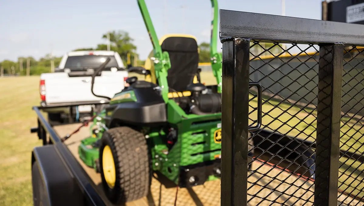 a john deere lawn mower is parked in the back of a 60pi trailer