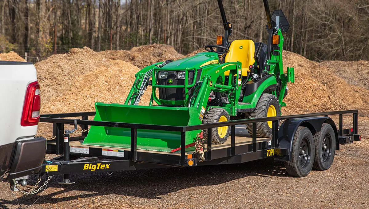 a john deere tractor is on a 70PI Tube Top Utility big tex trailer