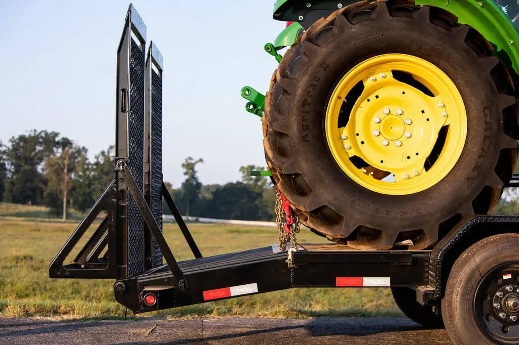 green tractor on trailer with mega ramps